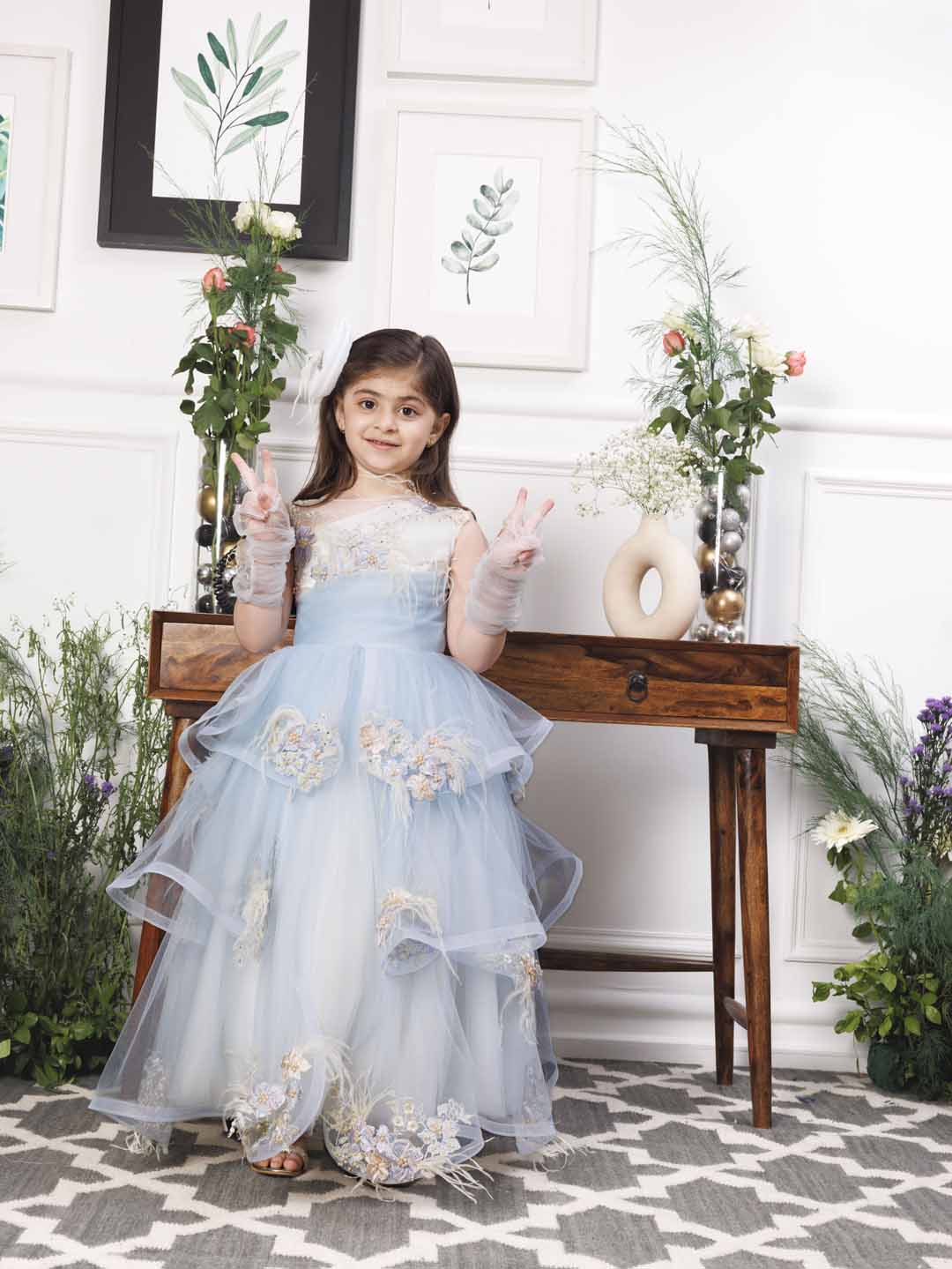 Daphne blue and white layered gown with flowers and feathers detailing