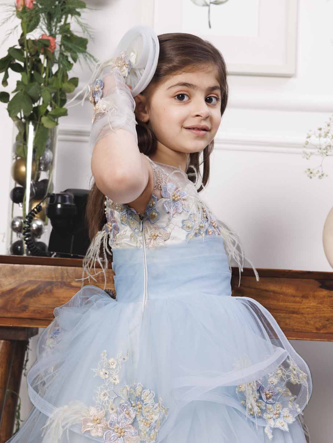 Daphne blue and white layered gown with flowers and feathers detailing