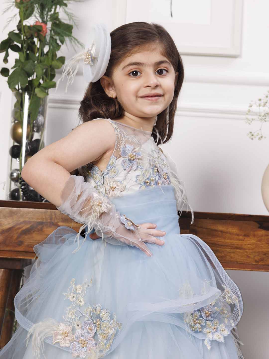 Daphne blue and white layered gown with flowers and feathers detailing