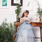 Daphne blue and white layered gown with flowers and feathers detailing