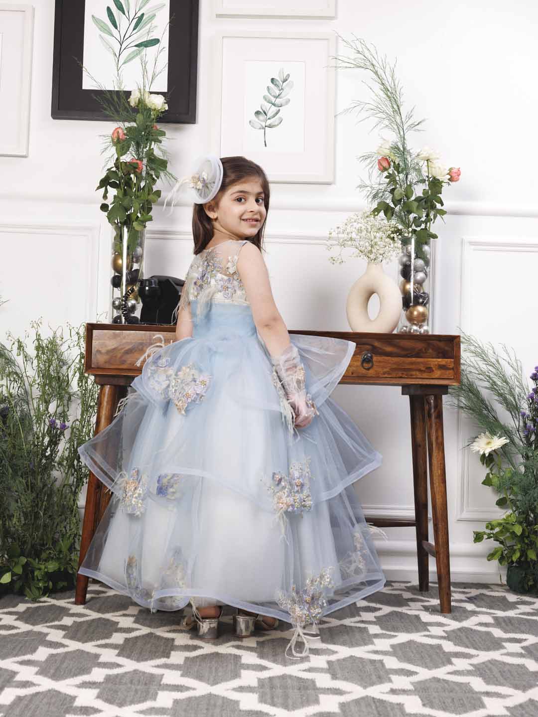 Daphne blue and white layered gown with flowers and feathers detailing
